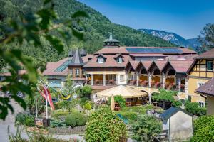a large hotel with a garden in front of a mountain at Scharfegger's Raxalpenhof - Zuhause am Land in Reichenau