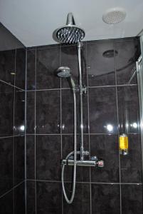a shower with a shower head in a bathroom at Oak Lodge B&B in Bude