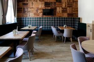 a restaurant with tables and chairs and a tiled wall at Hotel Gasthof Metzgerei Drei Linden in Fulda