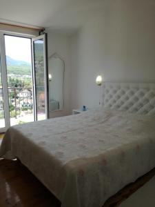 a bedroom with a large bed with a large window at Apartmani Mladina in Jelsa