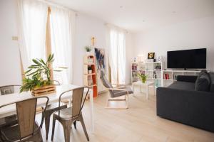 uma sala de estar com um sofá, uma mesa e cadeiras em LA SURFERA APARTMENT em Tarragona