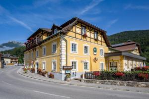 ein gelbes Gebäude an der Straßenseite in der Unterkunft Scharfegger's Raxalpenhof - Zuhause am Land in Reichenau