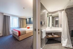 um quarto de hotel com uma cama e um lavatório em Holiday Inn Express Strathclyde Park M74, Jct 5, an IHG Hotel em Motherwell