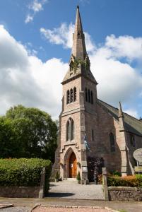 Una iglesia con un campanario encima. en The Auld Kirk, en Ballater