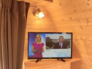 a flat screen tv sitting on top of a wooden wall at Hüttendorf Fränkische Schweiz in Pottenstein