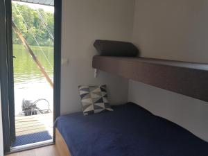 sypialnia z łóżkiem piętrowym obok okna w obiekcie Domki pływające Houseboat4U, Mazury w mieście Ruciane-Nida
