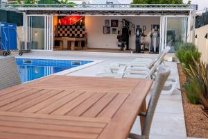 een patio met een houten tafel en stoelen bij villa Aqua-Jacuzzi-heatable pool-sauna-gym-snooker in Albufeira