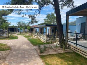 przejście obok budynku z drzewem w obiekcie Victoria Mobilehome in Padova Premium Camping Resort w mieście Banjol