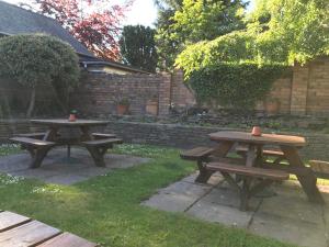 dos mesas de picnic con tazas encima en The White Horse Inn, Clun, en Clun