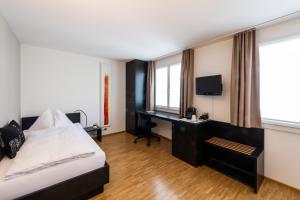 1 dormitorio con 1 cama y escritorio con ordenador en Hotel Bauernhof - Self Check-In Hotel, en Risch-Rotkreuz