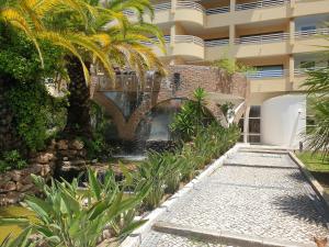 a building with a fountain in front of a garden at Marina Mar Vilamoura Apartment in Vilamoura