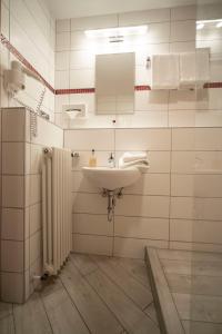 a bathroom with a sink and a mirror and a radiator at Hotel Liszt in Weimar