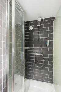 a bathroom with a shower with a glass door at Holiday Inn Express Strathclyde Park M74, Jct 5 by IHG in Motherwell