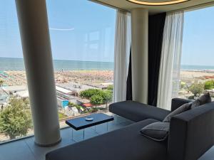 a living room with a couch and a view of the ocean at Hotel Commodore in Cervia