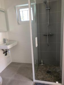 a bathroom with a shower and a sink at Le petit clos du Bessin in Longues-sur-Mer