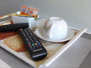 a remote control and a cup on a table at Kubo Bed and Breakfast in Cofimvaba +9 photos