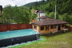 a small house with a swimming pool in a yard at Соломія in Slavske