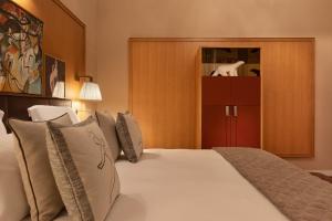 a bedroom with a large white bed with pillows at Hôtel Barrière Le Westminster in Le Touquet-Paris-Plage