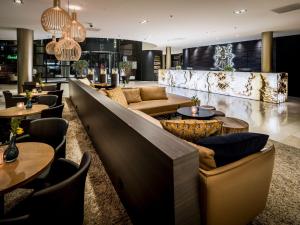 um bar com sofás, mesas e cadeiras em Hotel Van der Valk Maastricht em Maastricht