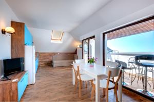 ネセバルにあるPanorama Blue Family Hotel and Free parkingのキッチン、ダイニングルーム(白いテーブル、椅子付)