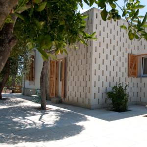 un edificio con un árbol delante en Agriturismo Villa Coluccia, en Martano
