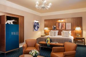 a hotel room with a bed and two chairs at Hôtel Barrière Le Westminster in Le Touquet-Paris-Plage