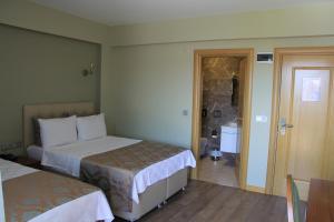 アーブシャ島にあるAlâ Avsa Hotelのベッド2台とバスルームが備わるホテルルームです。