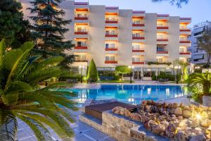 un hotel con piscina di fronte a un edificio di Oasis Hotel Apartments ad Atene