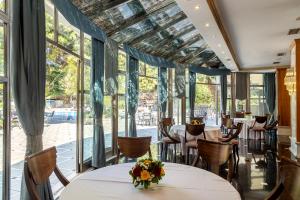 un ristorante con tavoli, sedie e ampie finestre di Oasis Hotel Apartments ad Atene