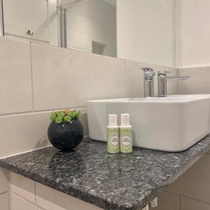 a bathroom with a sink and a counter with two bottles at Upstairs at 33 - Self check in boutique accommodation in Worcester Centre in Worcester