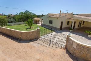 une clôture devant une maison avec une cour dans l'établissement Villa Monte Velho, à Albufeira