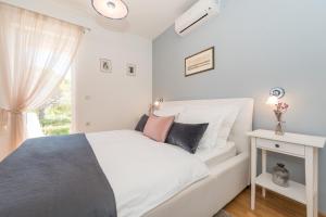 プリヴラカにあるHoliday Home Lukicaのベッドと窓のある白い寝室