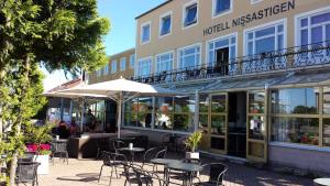 a restaurant with tables and chairs in front of a building at Hotell Nissastigen in Gislaved