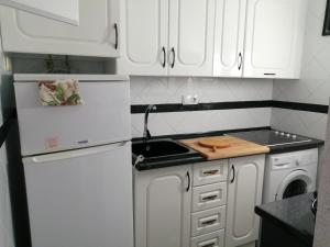 a white kitchen with white cabinets and a sink at Casas Holiday - Puerto Romano in La Mata