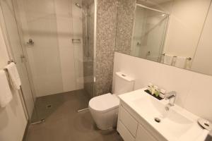 a bathroom with a toilet and a sink and a shower at Melbourne Knox Central Apartment Hotel Official in Wantirna