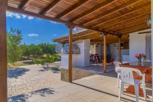 a patio with a wooden pergola and a table and chairs at Villa Sofia in Mesimvría