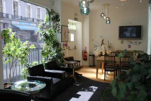 a living room with couches and a table with plants at Elysee Hyde Park in London