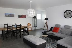ein Wohnzimmer mit einem Sofa, einem Tisch und Stühlen in der Unterkunft LE PLAZA HYPERCENTRE TERRASSE eT PARKING in Saint-Jean-de-Luz