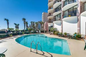 a swimming pool in front of a apartment building at Hosteeva Palms Resort 3BR 15th Floor Oceanfront in Myrtle Beach