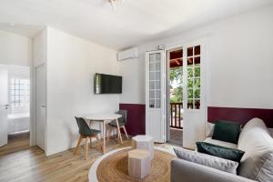 a living room with a couch and a table at Résidence Ker Enia Meublés de Tourisme in Cambo-les-Bains