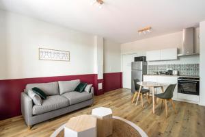 a living room with a couch and a table at Résidence Ker Enia Meublés de Tourisme in Cambo-les-Bains