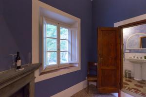 een blauwe badkamer met een wastafel en een raam bij Agriturismo La Fattoria di Capezzana in Carmignano