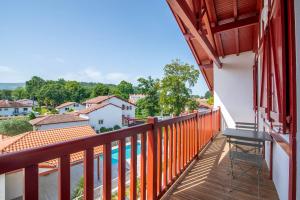a balcony with a view of a swimming pool at Résidence Ker Enia Meublés de Tourisme in Cambo-les-Bains
