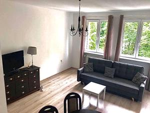 a living room with a couch and a tv at MoMi Apartament Blonia Szczecin Herbowa in Szczecin