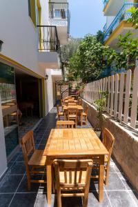 una fila de mesas y sillas de madera en un patio en Holy Pansiyon, en Kas