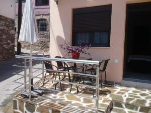 a table with chairs and an umbrella on a patio at Stelios House in Ayios Nikolaos Sithonia