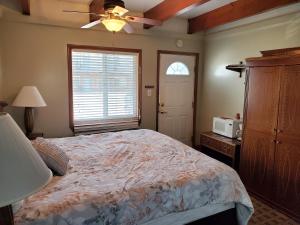 - une chambre avec un lit et un ventilateur de plafond dans l'établissement Golden Gate Lodging, à Plattsburgh