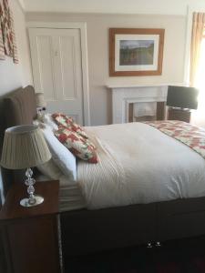 a bedroom with a bed and a table with a lamp at Moraydale Guest House in Elgin