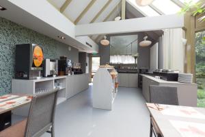 a kitchen with white counters and tables and windows at Flanders Lodge Hotel in Ieper