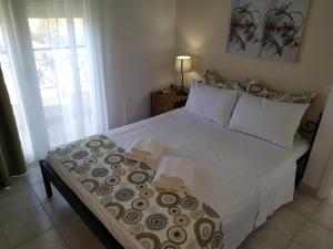 伊拉克里薩的住宿－Amalia Bay，卧室配有一张带白色床单和枕头的大床。